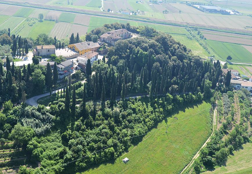 Veduta aerea del borgo di Pozzo tra cipressi e campi